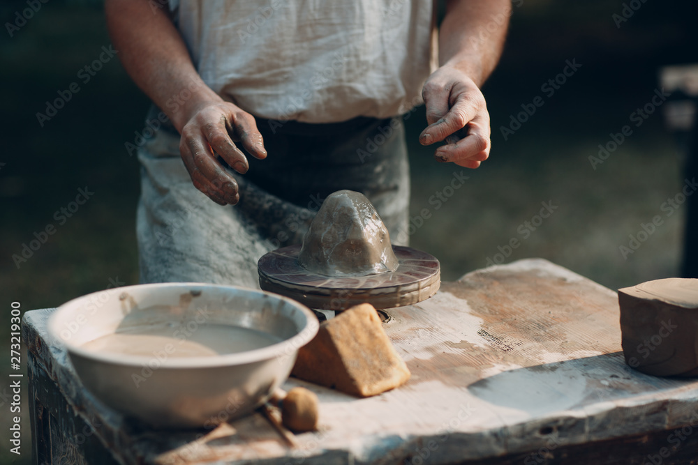 Potter makes clay pot jar on potter's wheel