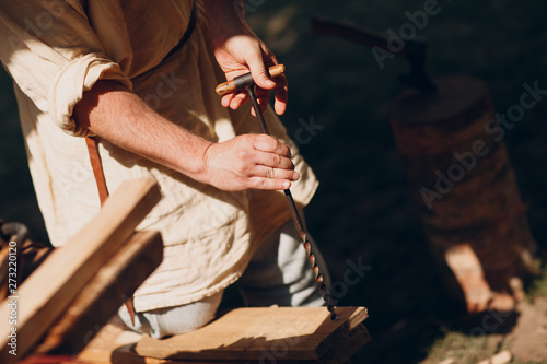 Carpenter drills wood with a hand drill © primipil