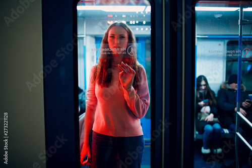 Positive redhead young female in subway train. Moscow metro.