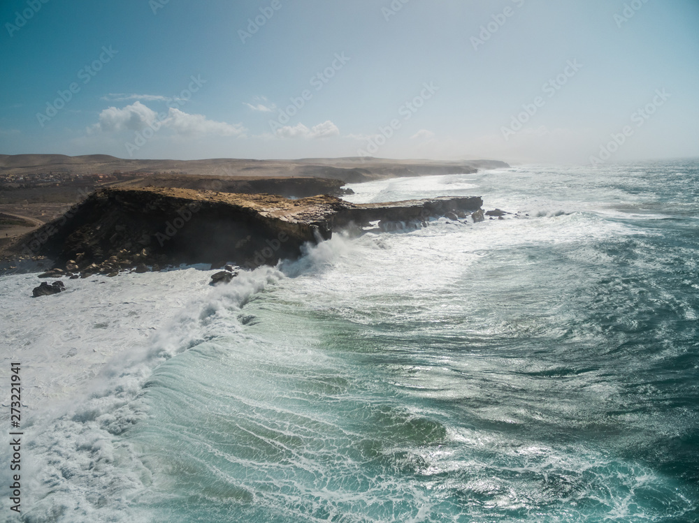 Aerial view of waves crashing of the rocks of punta Guadalupe in Fuerteventura, Canary Island. Aerial view of waves crashing of the rocks of punta Guadalupe in Fuerteventura, Canary Island.