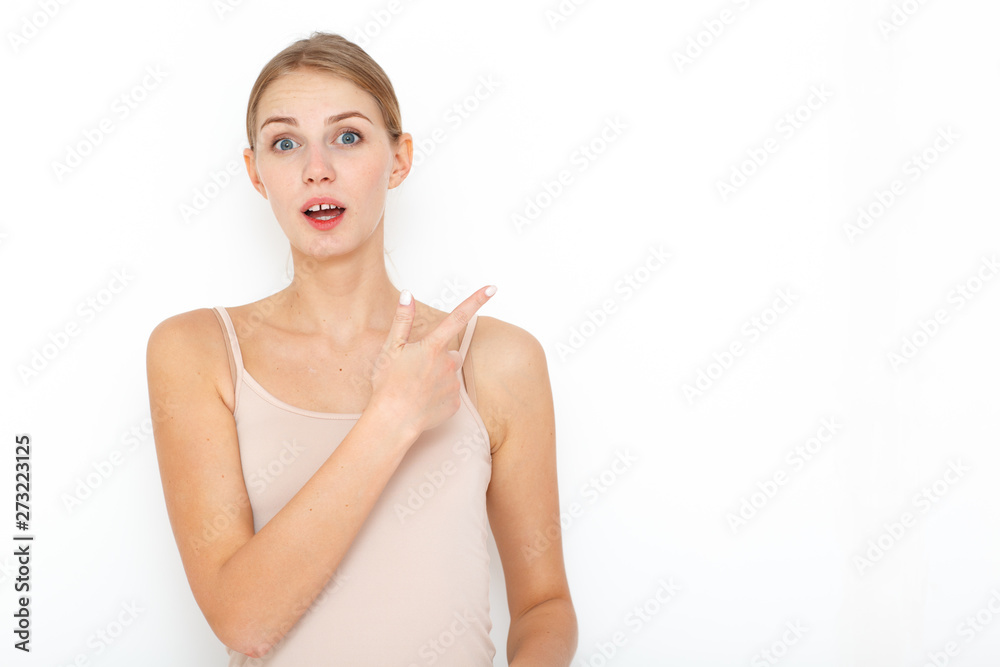 Portrait of happy surprised young woman model indicates with fore finger shows place for your advertisement or promotional text. Portrait of happy surprised young woman model indicates with fore finger shows place for your advertisement or promotional text.