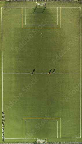 Aerial view of a football training players and shadows on synthetic surface football pitch on a summer day. photo