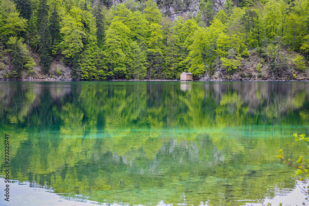 Mountain lake with turquoise water on the background of the green forest. Bavaria Mountain lake with turquoise water on the background of the green forest. Bavaria