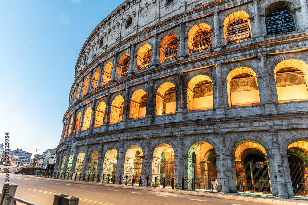 Fototapeta premium Colosseum, or Coliseum. Illuminated huge Roman amphitheatre early in the morning, Rome, Italy