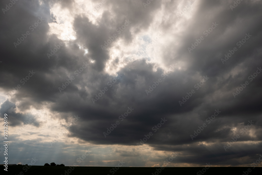 Backlit dramatic clouds above minimal landscape
