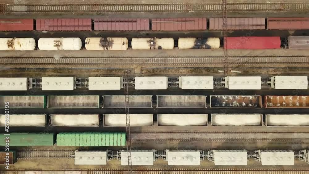 Freight railway cars at the railway station. Aerial view. Tanks and containers with cargo are on the rails on a sunny summer day. Commercial rail transportation Freight railway cars at the railway station. Aerial view. Tanks and containers with cargo are on the rails on a sunny summer day. Commercial rail transportation