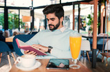 Young man reading a book in the cafe. Education, lifestyle concept