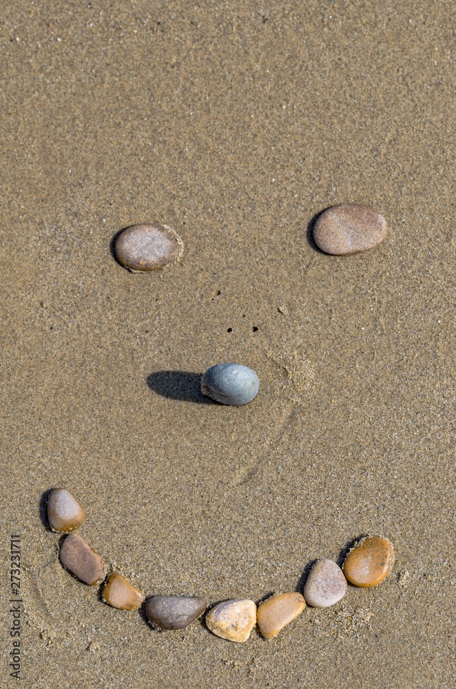 Stones forming a smiling face on the sand Stones forming a smiling face on the sand