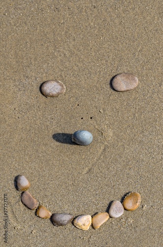 Stones forming a smiling face on the sand