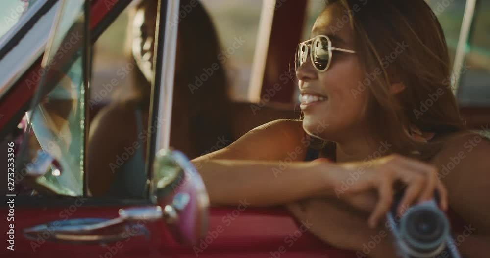 Young attractive woman sitting and smiling in a red vintage beach ...
