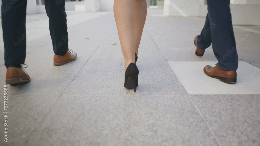 Legs of business people walking together outdoor. Low section of male and female colleagues walking together on street. Formal wear concept Legs of business people walking together outdoor. Low section of male and female colleagues walking together on street. Formal wear concept