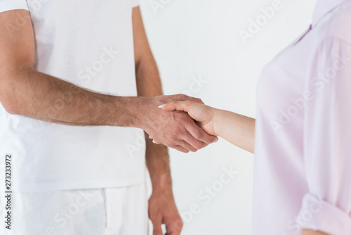 cropped view of man and woman shaking hands isolated on white © LIGHTFIELD STUDIOS