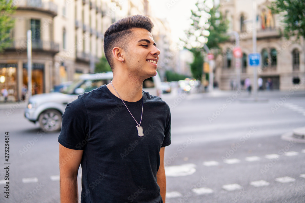 Young fashionable handsome man on the street of modern city. He looks happy
