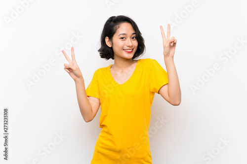 Asian young woman over isolated white background showing victory sign with both hands