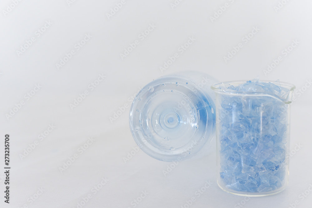 Bottle flake,PET bottle flake,Plastic bottle crushed,Small pieces of cut blue plastic bottles in beaker glass&Bottom of translucent bottle .Chemical concept Bottle flake,PET bottle flake,Plastic bottle crushed,Small pieces of cut blue plastic bottles in beaker glass&Bottom of translucent bottle .Chemical concept