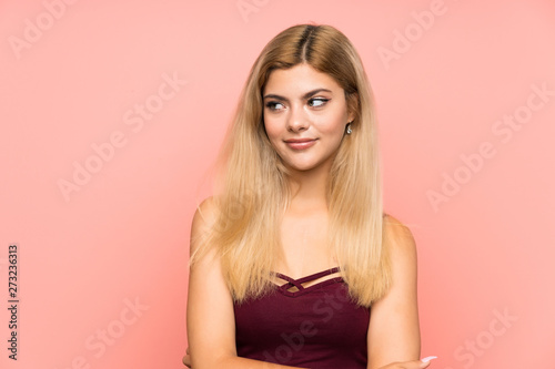 Teenager girl over isolated pink background standing and looking to the side