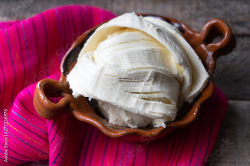 Canvas Print Fresh Oaxaca cheese in clay pot on wood background