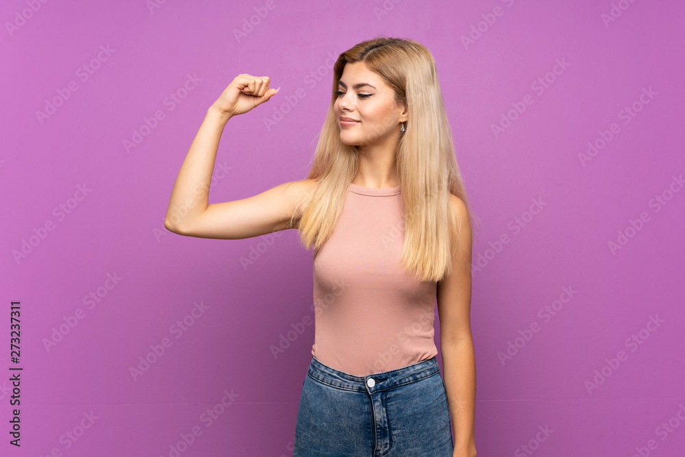 Teenager girl over isolated purple background doing strong gesture Teenager girl over isolated purple background doing strong gesture