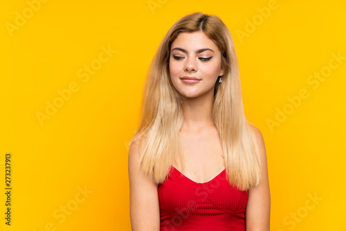 Teenager girl over isolated yellow background standing and looking to the side
