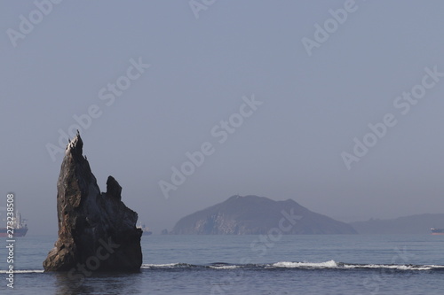 Alone rock island in the calm sea. Background for presentation, poster, post card and other graphic design with big place for your text