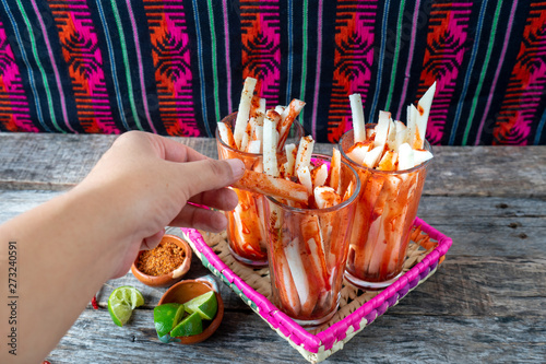 Mexican jicama fruit cutted with lime, chili powder and chamoy photo