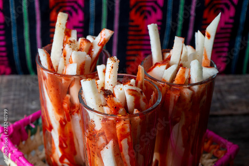 Mexican jicama fruit cutted with lime, chili powder and chamoy photo