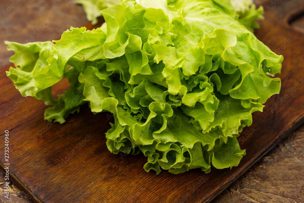 fresh Green leaf lettuce on an old cutting board. Diet food fresh Green leaf lettuce on an old cutting board. Diet food