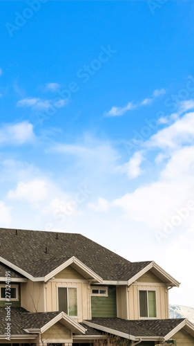 Foto Vertical House exterior with view of the dark pitched roof against a cloudy blue