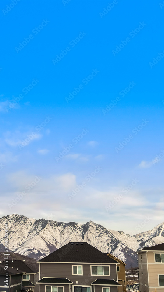 Vertical frame Exterior view of houses with mountain peak covered with snow in the background