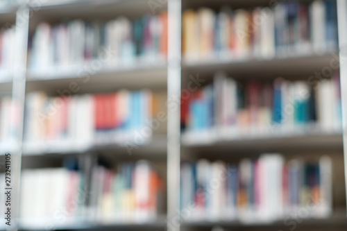 Blur image of shelf with books in library. Background.