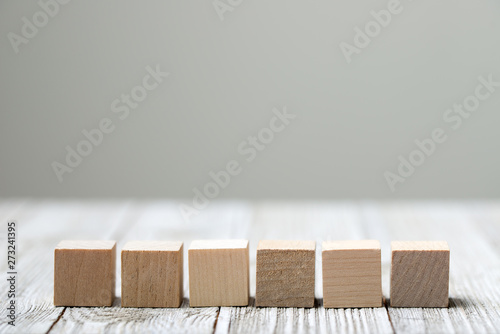 Fototapeta Naklejka Na Ścianę i Meble -  Six wooden toy cubes arranged in row on white grey wooden background
