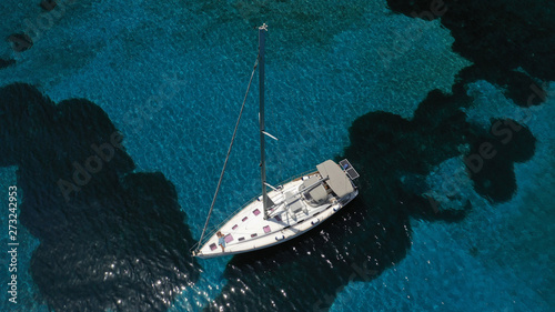 Aerial photo of sail boat docked in famous beach of Ornos, Mykonos island, Cyclades, Greece