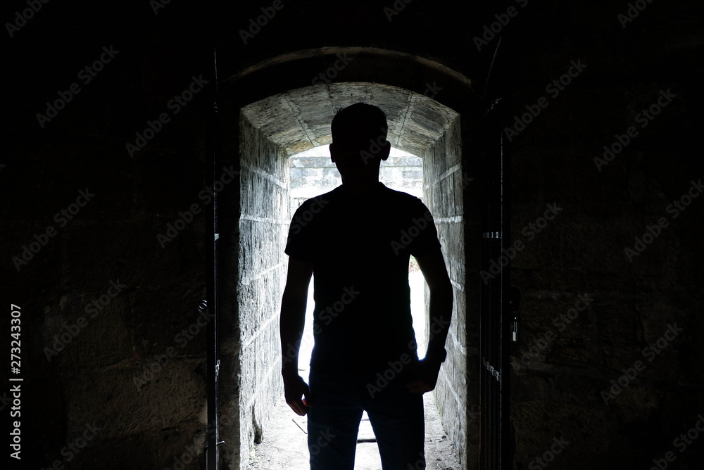 Silhouette of a man in the entrance of a spanish era tunnel in Intramaruos 