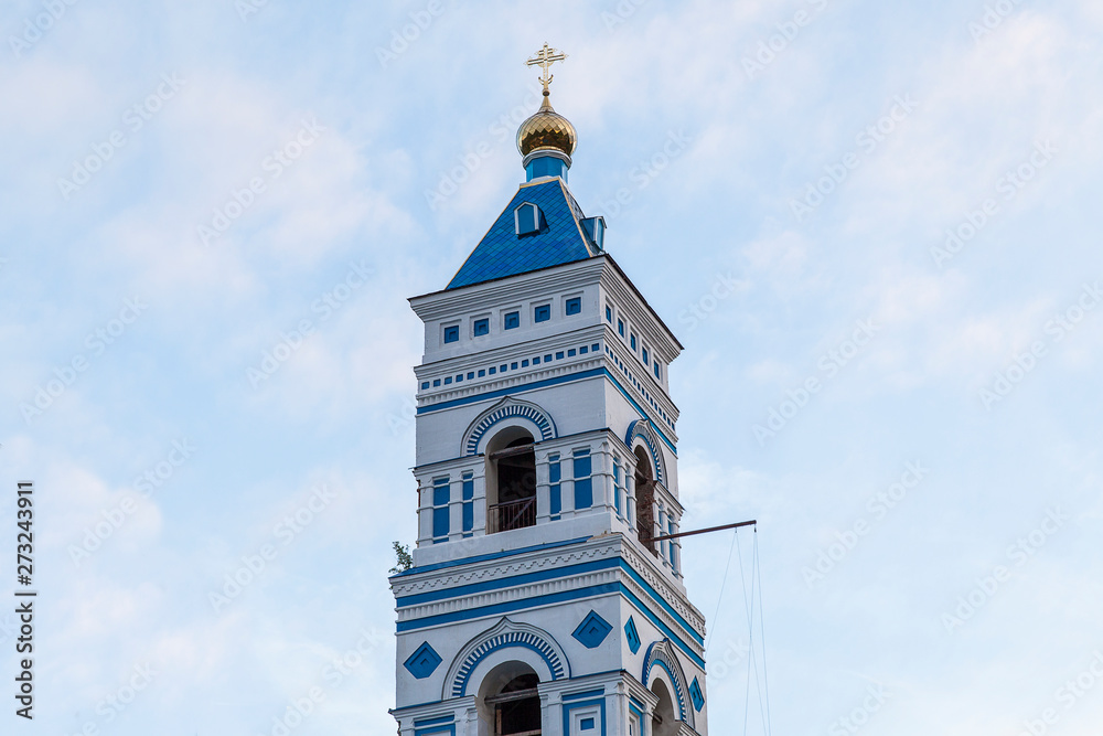 The picturesque bell tower of a Christian temple with a golden dome
