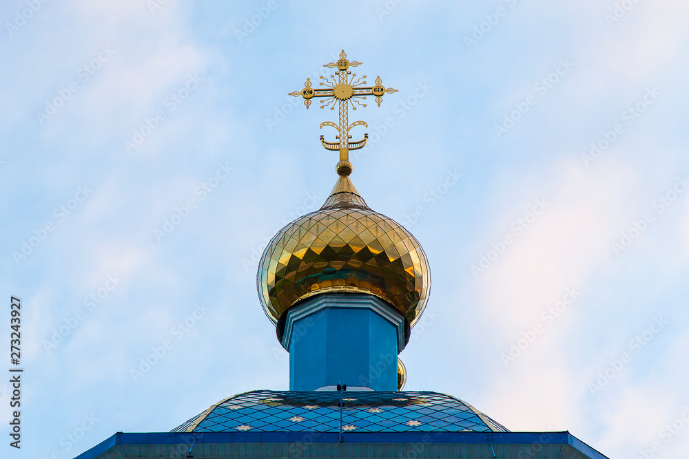 Golden dome of an orthodox temple against a cloudy sky