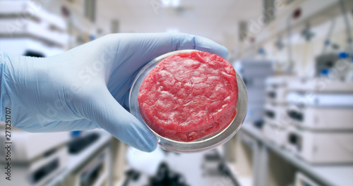 Close up of a scientist is showing in camera the cultured artificial meat sample in a modern laboratory.
