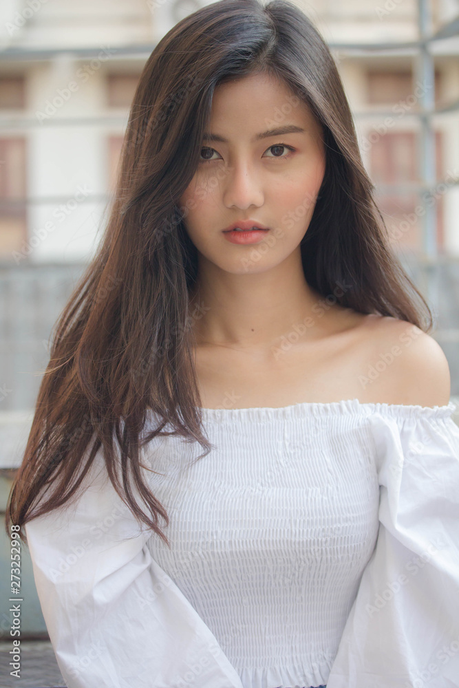 Portrait of thai adult beautiful girl White shirt blue jeans relax and smile Portrait of thai adult beautiful girl White shirt blue jeans relax and smile