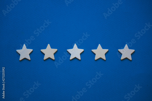Wooden cubes in the form of stars arranged in a row on a blue background