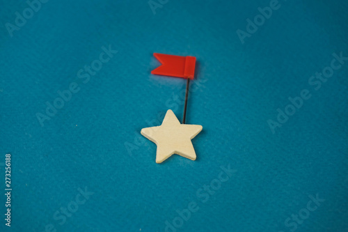 wooden cubes in the form of stars lined up in a chain and one star with a red flag, the star with the flag symbolizes the commander photo