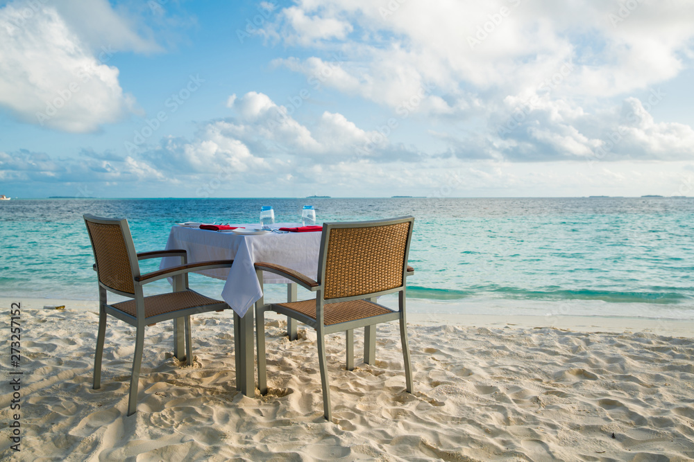Table outdoor next to sea scenic prepare for special romantic dinner time.