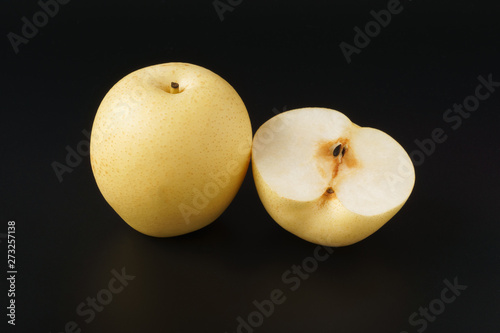 Sand pear full and half fruit isolated on black background photo