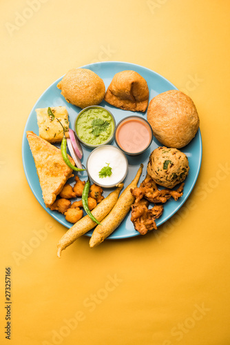 Indian Tea time snacks  in group includes Veg Samosa, Kachori/kachaudi, aloo bonda, khaman dhokla, bread, onion,chilli and moong pakora/pakoda/bhaji/bhajji/Bhajiya/bajji with sauces, selective focus photo