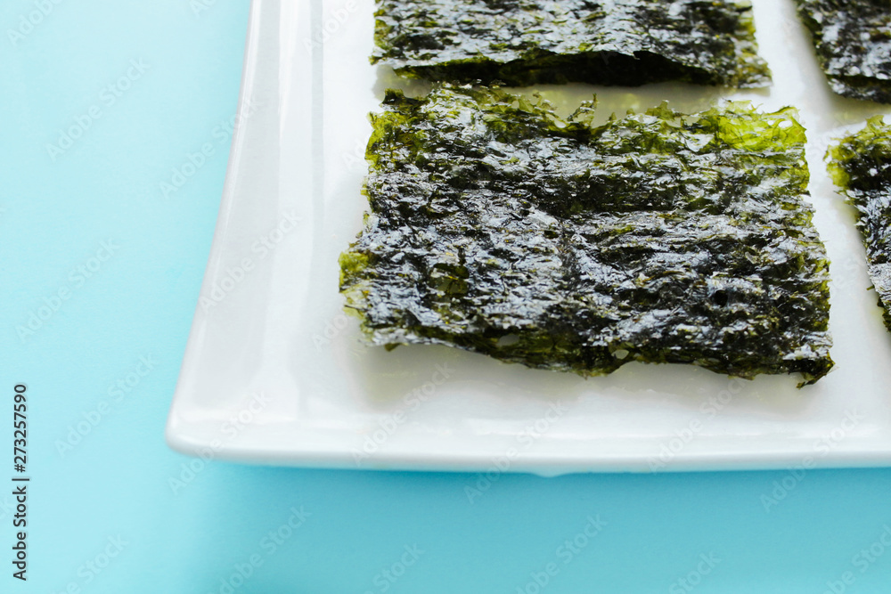 Dry korean organic seaweed isolated on blue background.Crispy seaweed.Healthy food concept.top