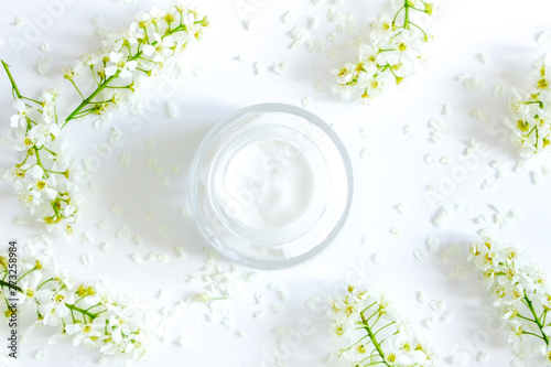 Daily  face cream.Organic natural cosmetic product .Jar with cream and flowers on white background. Woman s skincare routine. Beauty blogger flat lay concept.Place for your text or logo.