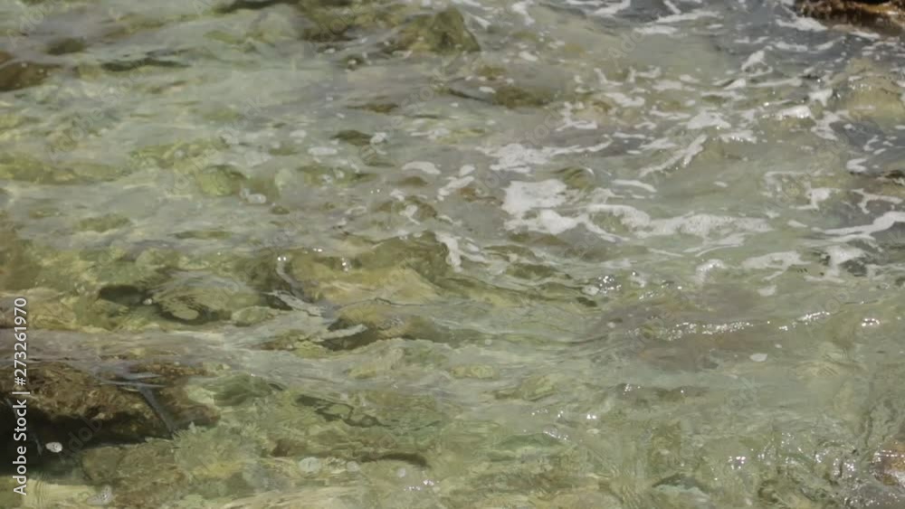 Blue water and textured foam at the stone shore. Texture of waves and sea water from above. Blue water and textured foam at the stone shore. Texture of waves and sea water from above.