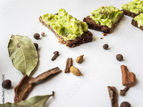 Avocado and bread. Avocado pate spread on slices of black bread. Spices and spices