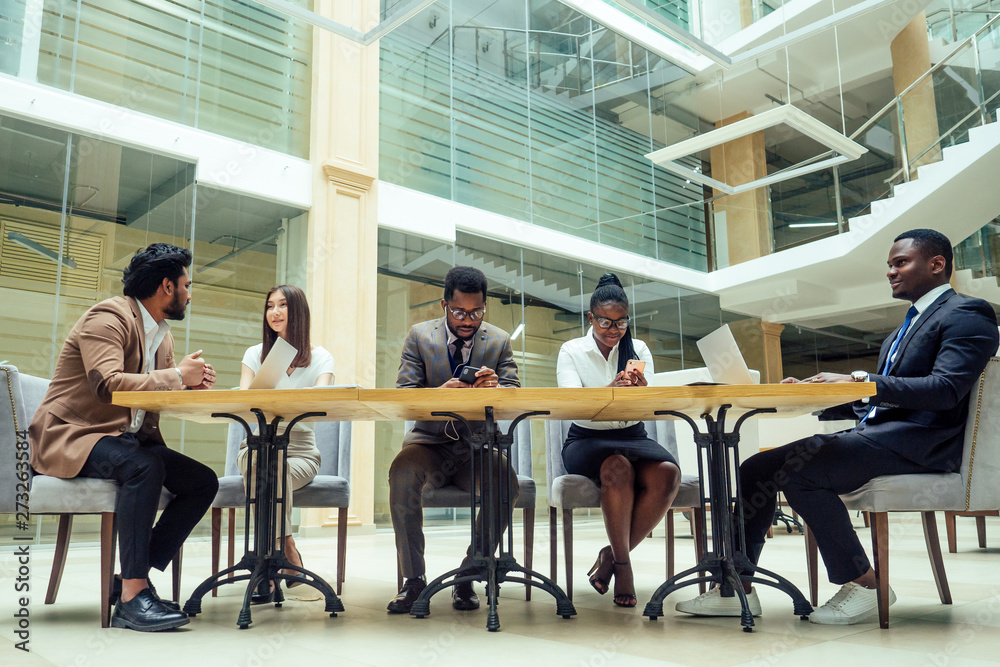 well-dressed business afro american men making a report to subordinate employees in a modern office