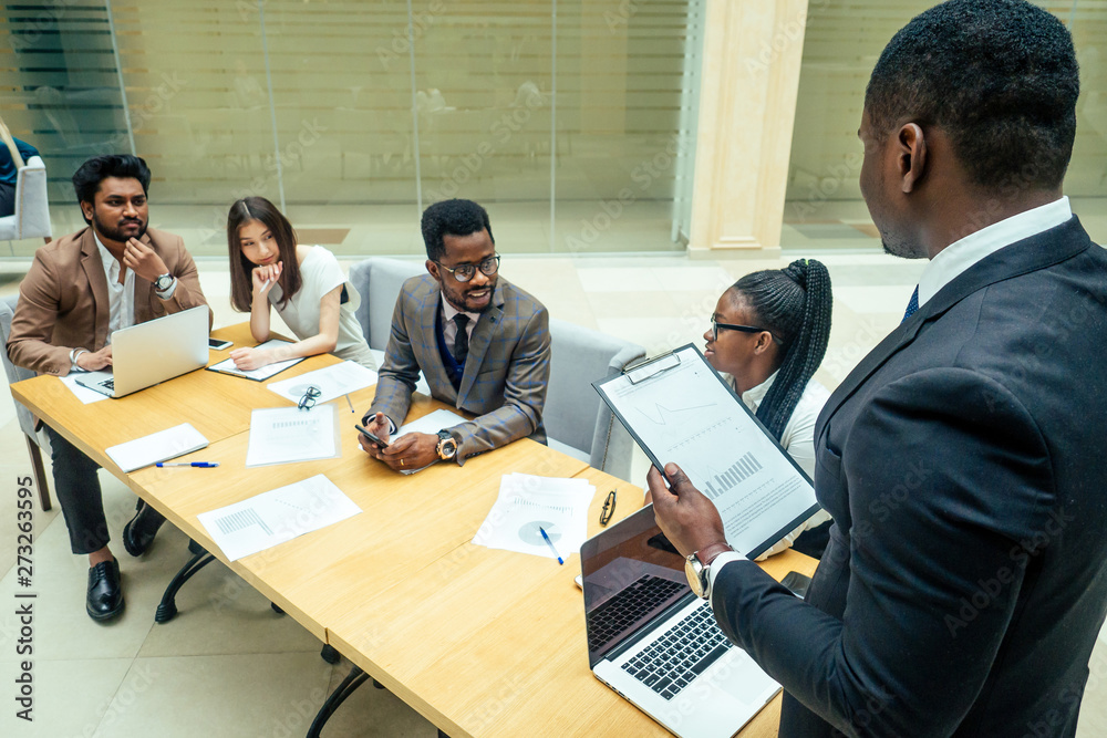 well-dressed business afro american men making a report to subordinate employees in a modern office well-dressed business afro american men making a report to subordinate employees in a modern office