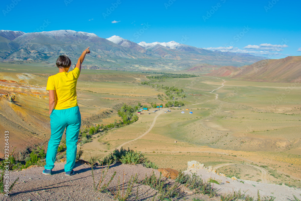 Happy woman standing on rock. Mars mountains, the name of colored mountain protrusions in the mountains of Kyzyl-Chin. Altai, Russia. A delightful landscape of unreal beauty.