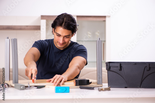 Young man repairing furniture at home 